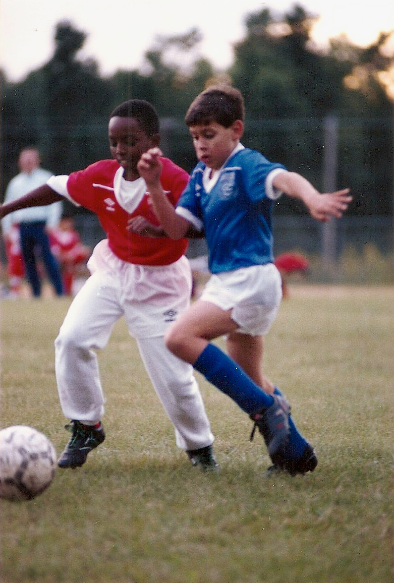 Boys competing for soccer ball during game